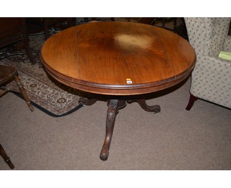 A Victorian mahogany turnover top breakfast table, carved acanthus leaf decoration to tripod legs terminating in ceramic cast