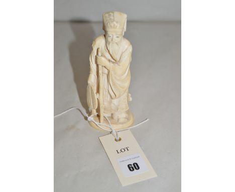 A 19th Century Japanese ivory okimono figure of an elderly man with stick and fan, signed.