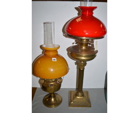 A Victorian brass oil lamp with later red glass shade, raised on a corinthian column; another brass oil lamp by Aladdin, no. 