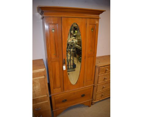 An Art Nouveau mahogany wardrobe, bevelled mirror door above a single drawer, with decorative design to two panels, 96cms wid