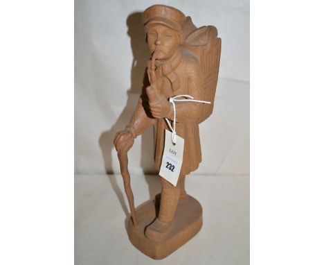 A 20th Century German carved oak figure, by Mads, Wehrenberg, Munster, depicting a man making a pipe, holding a stick and car