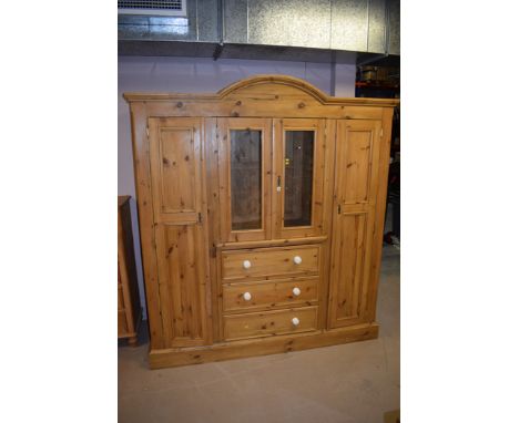 A modern polished pine Victorian style wardrobe, centre display section section glazed doors above three drawers flanked by h