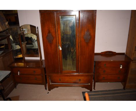 A 1930's three-piece oak bedroom suite, comprising: wardrobe with bevelled mirror door, 105cms wide; a chest of three drawers