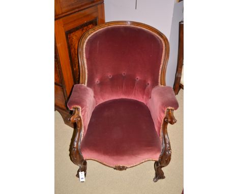 A Victorian walnut openwork armchair, raised on cabriole legs terminating in ceramic castors, upholstered in burgundy velour.