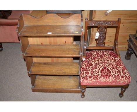 A late Victorian mahogany nursing chair, carved back upholstered in floral patterned material, the turned legs terminating in