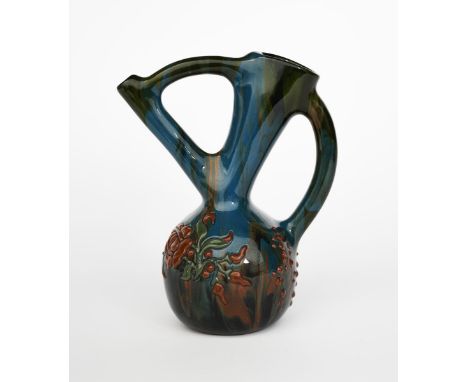 A Sunflower Pottery ewer by Sir Edmund Elton, ovoid with angled handle and tube neck, applied with slip flowers and foliage, 