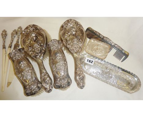 An eight-piece matching set of hallmarked silver Art Nouveau vanity items including hairbrushes, glove stretchers, small tray