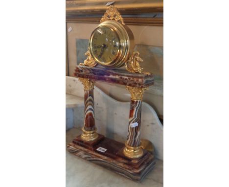 20th century onyx and gilt metal mantle clock, with modern movement standing on classical pillars above tiered base