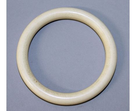 AN EARLY 20TH CENTURY PLAIN IVORY BANGLE, 3.1in diameter, the inner rim 2.3in diameter.