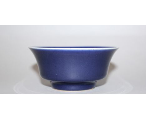 A CHINESE BLUE GLAZED PORCELAIN BOWL, the sides rising to an everted rim, the base with a Qianlong seal mark, 4.6in diameter 