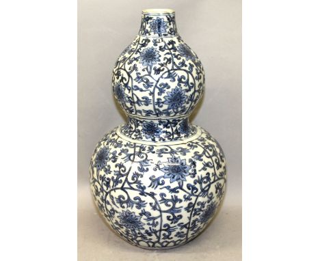 A CHINESE MING STYLE BLUE & WHITE DOUBLE GOURD PORCELAIN VASE, the sides of the fluted body decorated with an overall formal 