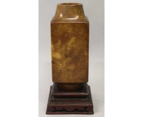 A CHINESE JADE-LIKE STONE CONG VASE, together with a fitted wood stand, the stone of predominantly brown mottled tone, 11.5in