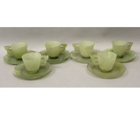 A 20TH CENTURY CHINESE GREEN JADE-LIKE SET OF CUPS & SAUCERS, comprising six flaring cups with stylised dragon handles and si