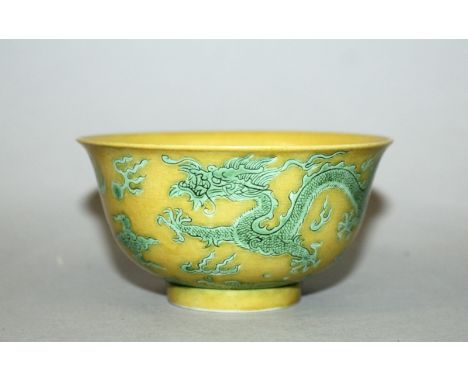 A CHINESE GREEN ENAMELLED YELLOW GROUND PORCELAIN DRAGON BOWL, the sides decorated with two dragons amidst flame and cloud sc