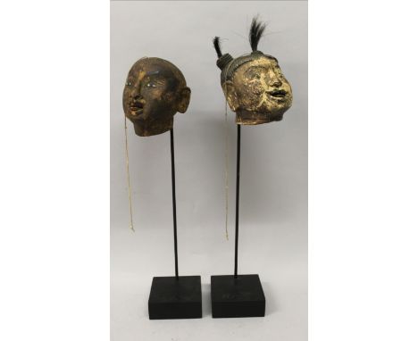 AN UNUSUAL PAIR OF 19TH/20TH CENTURY CHINESE PUPPET HEADS, mounted on fixed display stands, each with moveable tongue, 19.25i