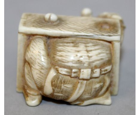 A JAPANESE MEIJI PERIOD IVORY NETSUKE, carved in the form of an oni disappearing inside a wood grained box, 1.1in wide & 0.8i