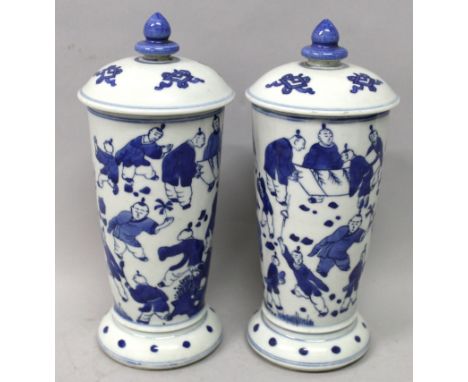 A PAIR OF CHINESE BLUE & WHITE PORCELAIN JARS & COVERS, each flaring body decorated with a multitude of playing boys, 9in hig