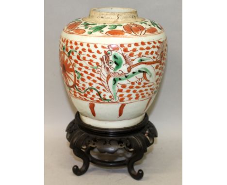 A 17TH CENTURY TRANSITIONAL/EARLY KANGXI PERIOD WUCAI STYLE PORCELAIN JAR, together with a fixed wood stand, the sides painte