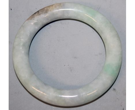 ANOTHER GOOD QUALITY 19TH/20TH CENTURY CELADON JADE BANGLE, the predominantly pale green stone with white and russet inclusio