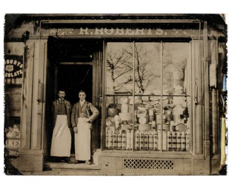 * Shop Front. Quarter-plate ambrotype of a grocer's shop front, circa 1900, showing two men with aprons in the doorway of 'R.