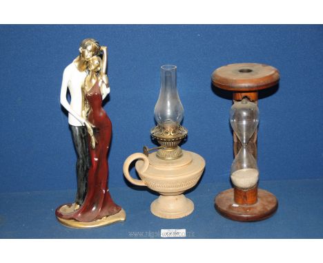 A resin figure of a couple, plus a wooden egg timer and a small china oil lamp.