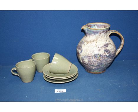 A jug and three coffee cups and saucers by Studio Pottery having Bernard Leach pottery marks.