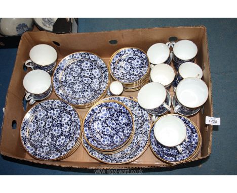 A good quantity of china in allover blue and white blossom design with gilt rim including, breakfast cups, saucers and plates