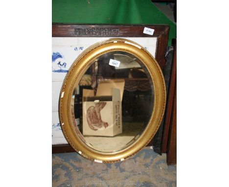 An oval gilt framed bevelled edge hanging Mirror, (some losses to frame) 21" x 16 1/2".