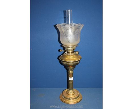 A single burner brass column Oil Lamp with brass reservoir, glass shade and chimney, (some chips to base of lamp), 27'' tall 