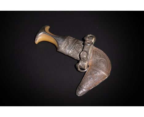 A Yemeni Silver and Horn Jambiya Dagger with Ornate Sheath.A curved Yemeni jambiya dagger featuring a hilt composed of horn w