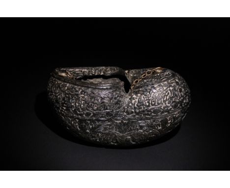 An Islamic  Kashkul Beggar's Bowl with Calligraphic and Floral Engravings.A dark-toned Kashkul featuring an intricately engra