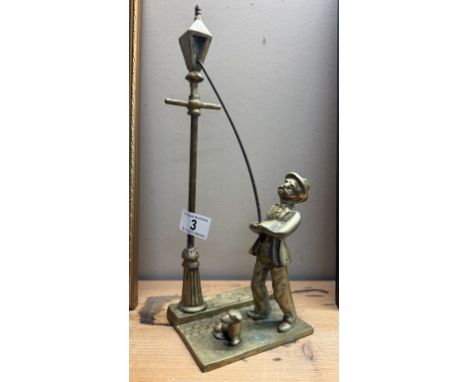 A solid brass figure of a Victorian lamp lighter with dog