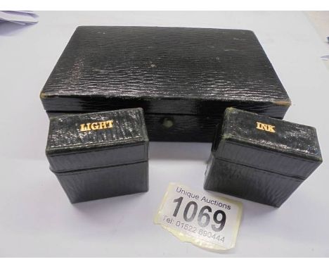 An early 20th century travelling case containing an inkwell and a light.