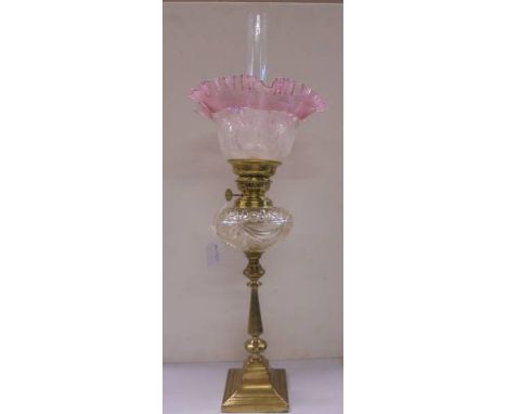 A Victorian oil lamp on a brass base with cut glass font and acid etched shade.