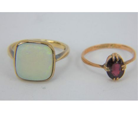 A 9ct gold ring set with a square white opal, size L, and a 9ct gold garnet set ring size K. Combined gross weight: 4.5 grams