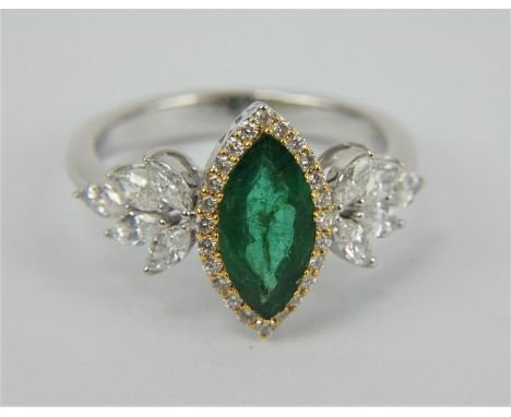 An18ct white gold marquis cut Colombian emerald and diamond ring. The emerald&nbsp; approximately 1ct surrounded by small dia