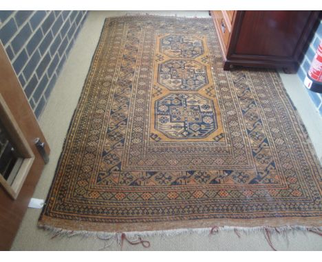 A Beluch rug with three repeating medallions on a brown ground within a multiple step to border 190 cms x 128 cms