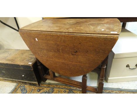 A 20th Century oak oval gate-leg drop-leaf dining table in the 18th Century manner