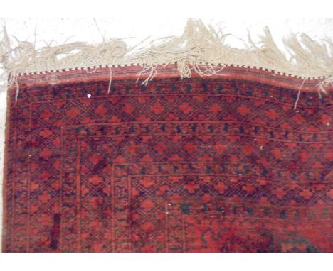 A Bokhara rug with allover elephant foot medallions on a red gorund within a multiple step border 400 cms x 286 cms