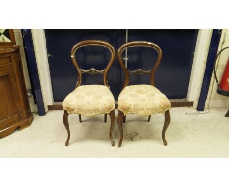 A set of four Victorian mahogany balloon back dining chairs, the seats with shaped front to cabriole legs with floral decorat