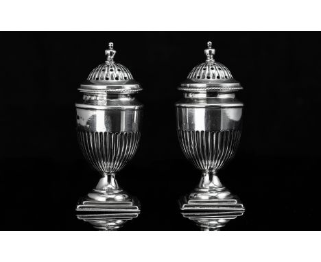 A Fine Pair of Sterling Silver Pepperettes of Classical Form, with reeded bodies, standing on stepped bases.  Hallmark Birmin