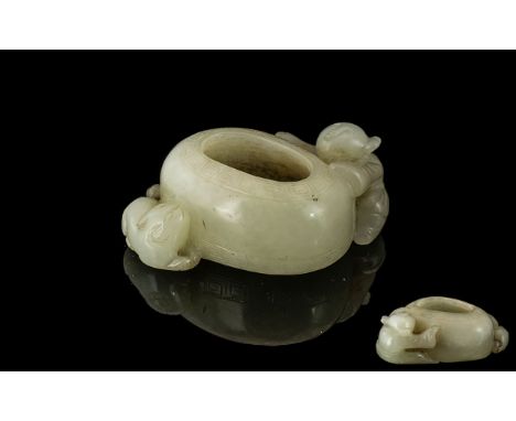 A Brush Pot in White Jade depicting a boy climbing on side. Measures 2 inches wide.