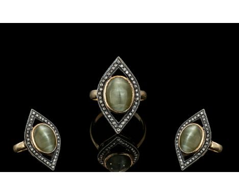 An Antique Dress Ring, set with a central pale green Cabochon, with old rose cut diamond border.  Later silver shank.