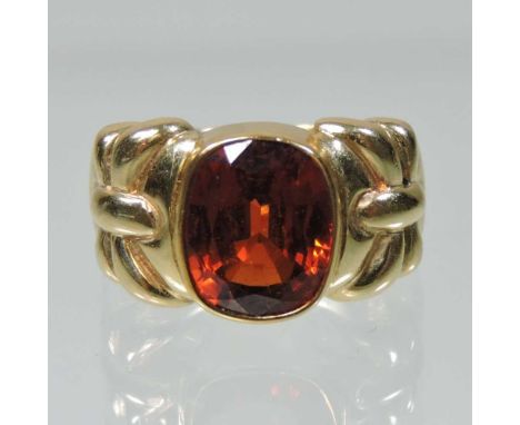 A 14 carat gold hessonite garnet single stone collet set ring, with tied ribbon design shoulders, size M, 9.6g grossCondition