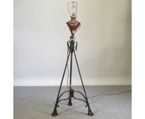 An Arts and Crafts wrought iron and brass standard lamp, with a copper reservoir124cm high