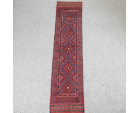A Turkish runner, with a row of five central medallions, on a red ground250 x 58cm
