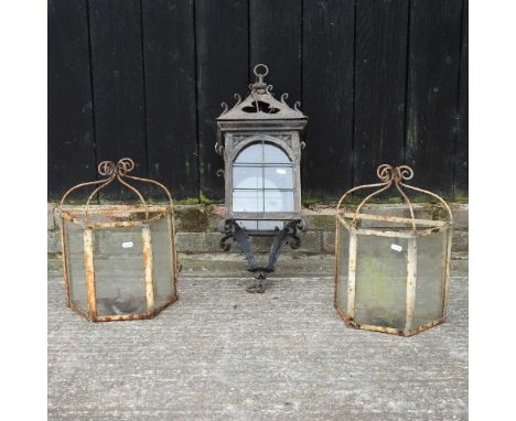 An ornate wrought iron hanging lantern, 66cm high, together with a pair of white painted wall lanterns (3)