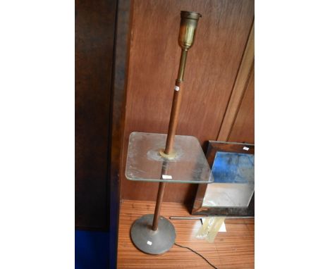 An early 20th century library lamp with brass and turned wood base and glass shelf.