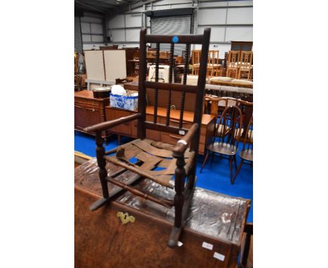 An antique childs chair with bobbin turned back.