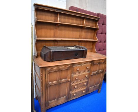 A traditional dark stained Ercol or similar kitchen dresser